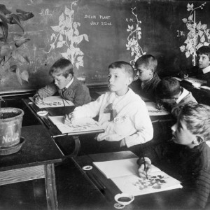 Boys engaged in a drawing class at an English school during the First World War. Their subject is a potted plant.